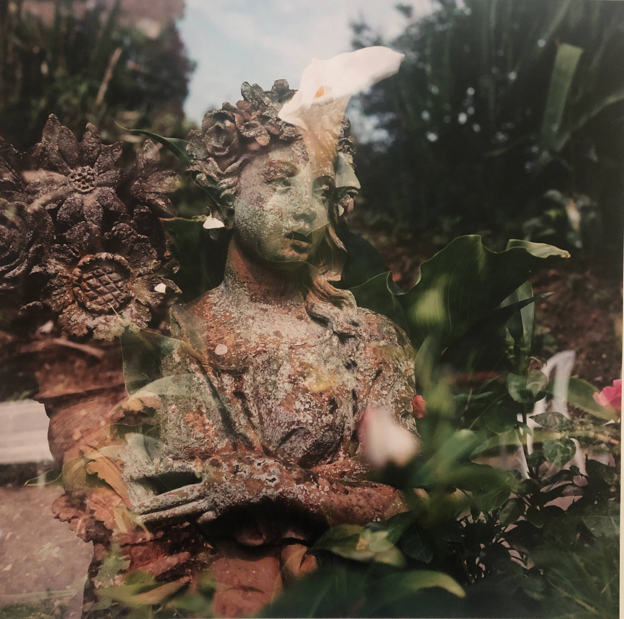 Photograph of a stone sculpture surrounded by green.